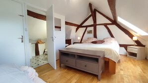 Une chambre à coucher avec un plafond en bois, un lit, une table de chevet et une commode.