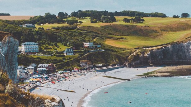 Une ville côtière dotée d’une plage, de falaises et d’une formation rocheuse remarquable.