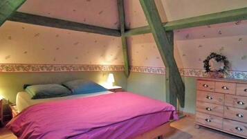 Ein Schlafzimmer mit Bett, Kommode und einer dekorativen Kranzleiste an der Wand.