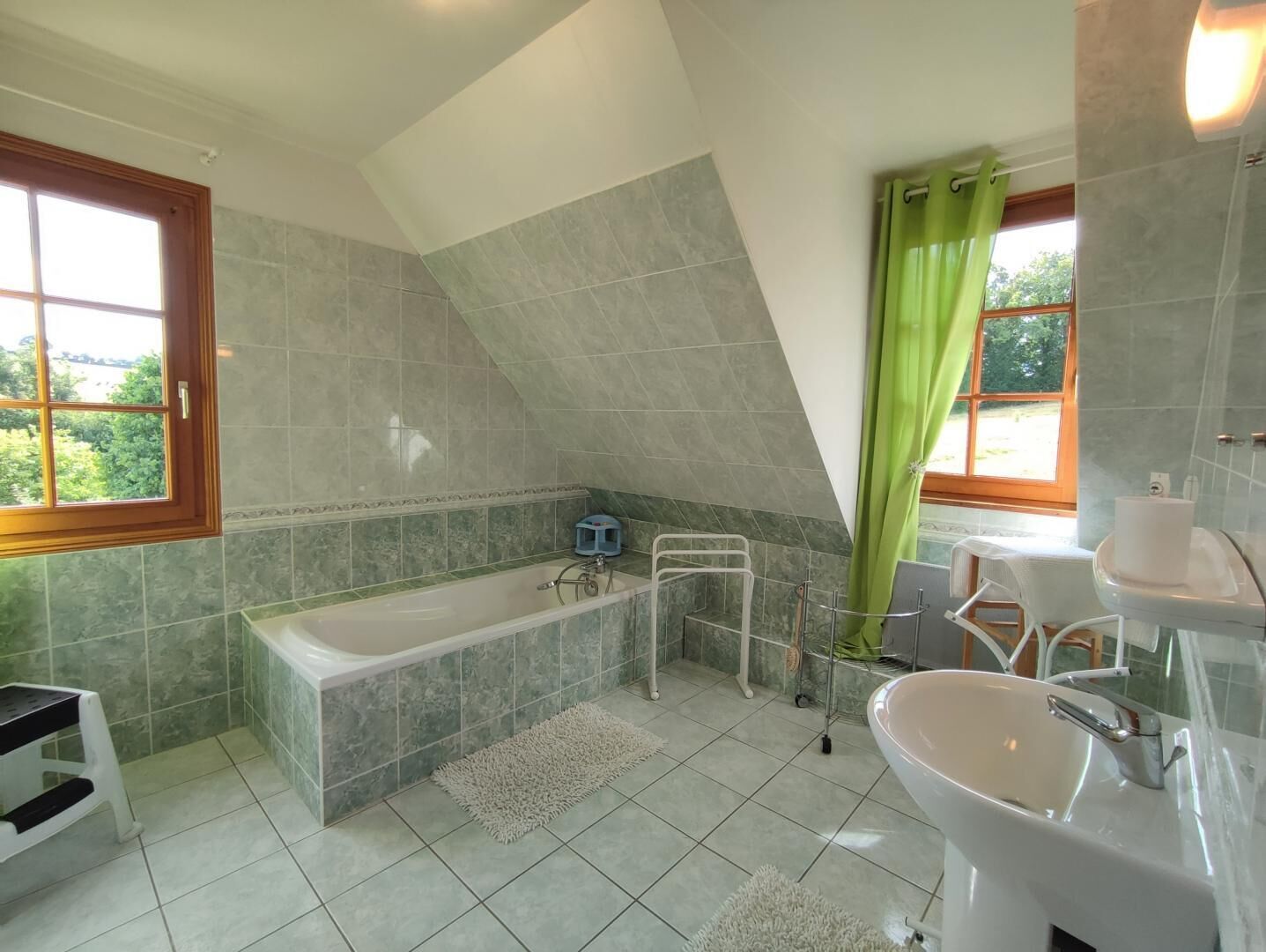 A bathroom with a bathtub, a sink, and a shower area.