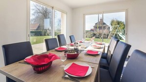 A dining area with a table set for four, large windows, and a view of the outdoors.