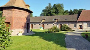 A brick building with a prominent tower, a central courtyard, and a red-tiled roof. - Gîtes de France® - La Masûre (ST MARTIN LE GAILLARD)