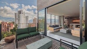 Eine moderne Wohnung mit Balkon, großen Fenstern und Blick auf die Stadt.