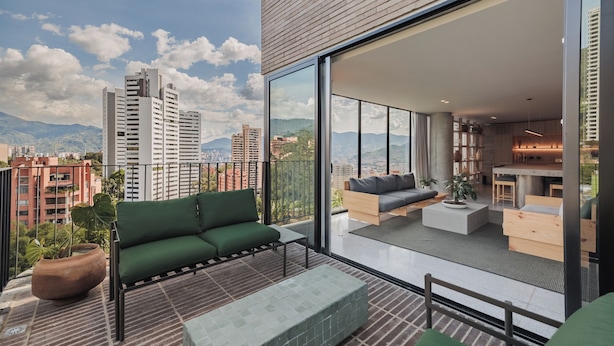 Eine moderne Wohnung mit Balkon, großen Fenstern und Blick auf die Stadt.