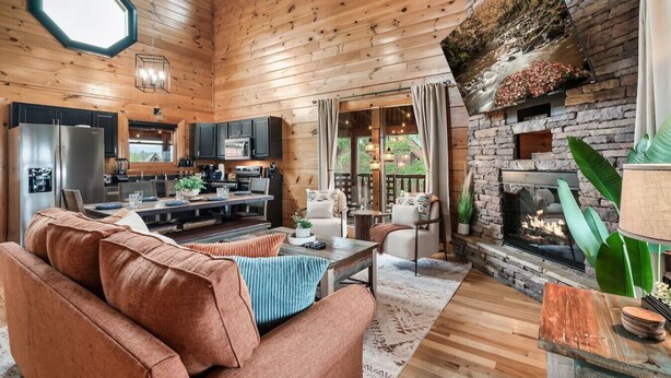 A cozy cabin interior with a living room, kitchen, and fireplace. - Spring Break Retreat: Gorgeous Views, Sauna & Spa (Sevierville)