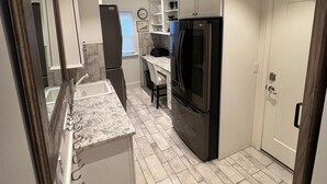 A modern kitchen with white cabinets, a granite countertop, and a stainless steel refrigerator. - Stunning 4-br, 4-bath brick, and stucco luxurious retreat in Reno Old Southwest. (Reno)