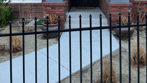 A two-story house with a brick facade, a dark front door with decorative glass panels, and a number '110' above the entrance. - Stunning 4-br, 4-bath brick, and stucco luxurious retreat in Reno Old Southwest. (Reno)