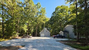A gravel driveway leading to a house with a garage, surrounded by trees. - 3 Bedroom House at Pine Forest Hideaway Near UNC (Chapel Hill)