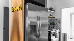 A modern kitchen with a stainless steel refrigerator, a built-in oven, and a water dispenser. - 4BR/3BA Home Near Downtown ATL, Stadium & Beltline (Atlanta)