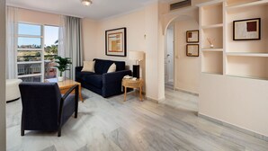 A modern living room with a sofa, a small table, and a lamp. There is a balcony with a view of the outside. - Alfresco Stays Mijas Costa Dream Escape (Mijas Costa)