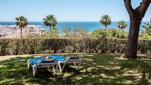 A view of a coastal property with a pool area, palm trees, and a hedge. - Alfresco Stays Mijas Costa Dream Escape (Mijas Costa)