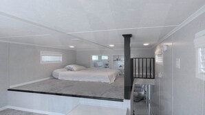 Ein Schlafzimmer mit einem Bett, einem Schreibtisch und einem Fenster.