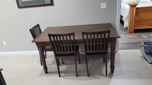 Un comedor con una mesa rectangular de madera y cuatro sillas.