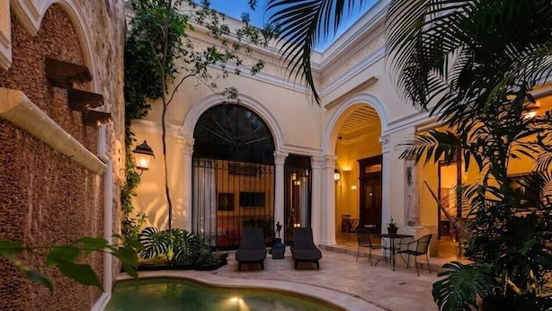 A courtyard with a pool, seating areas, and a building with arches and columns. - La Casa del Centro, Mérida by Cercana  (Mérida)
