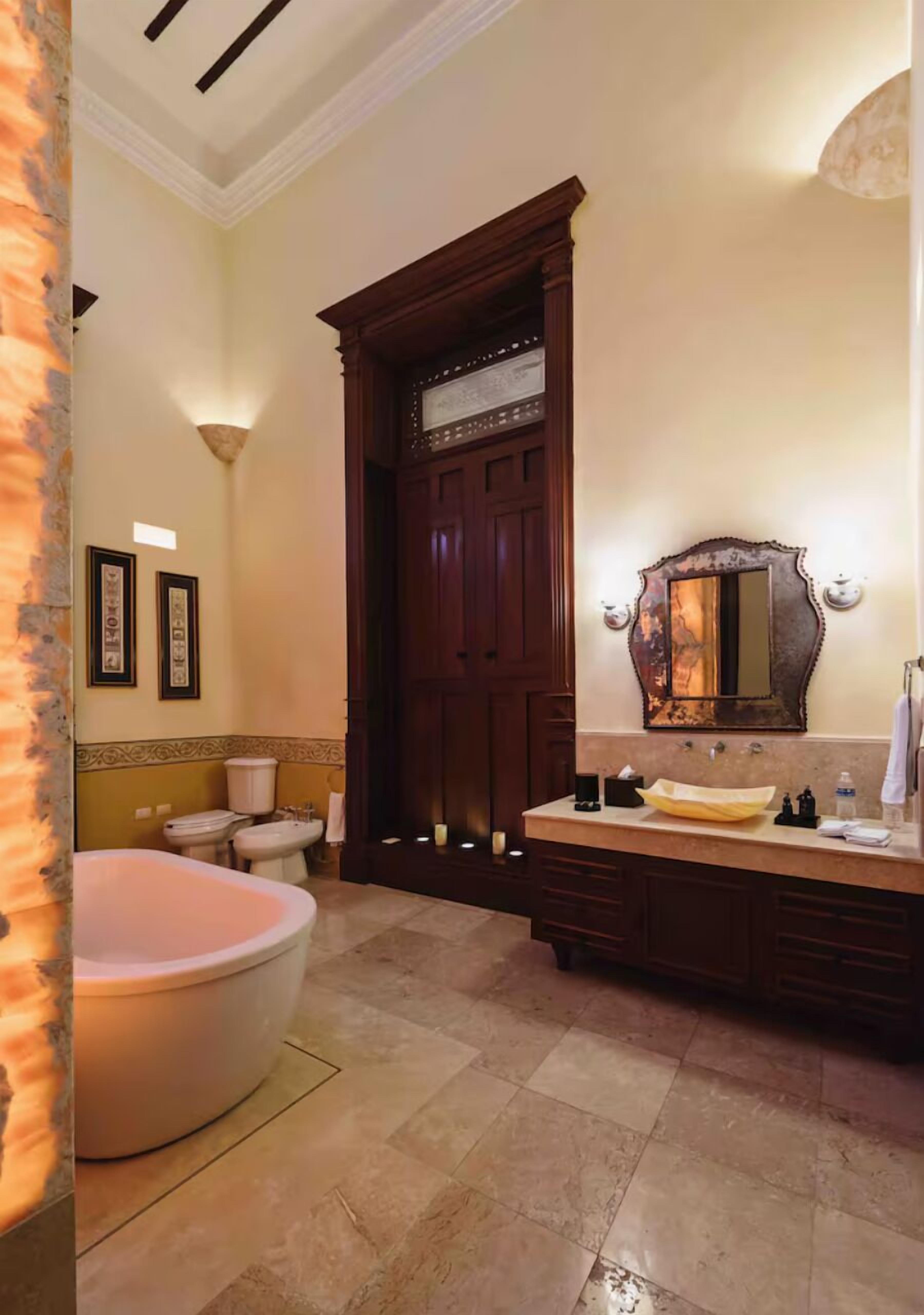 A bathroom with a bathtub, toilet, and vanity with a mirror.