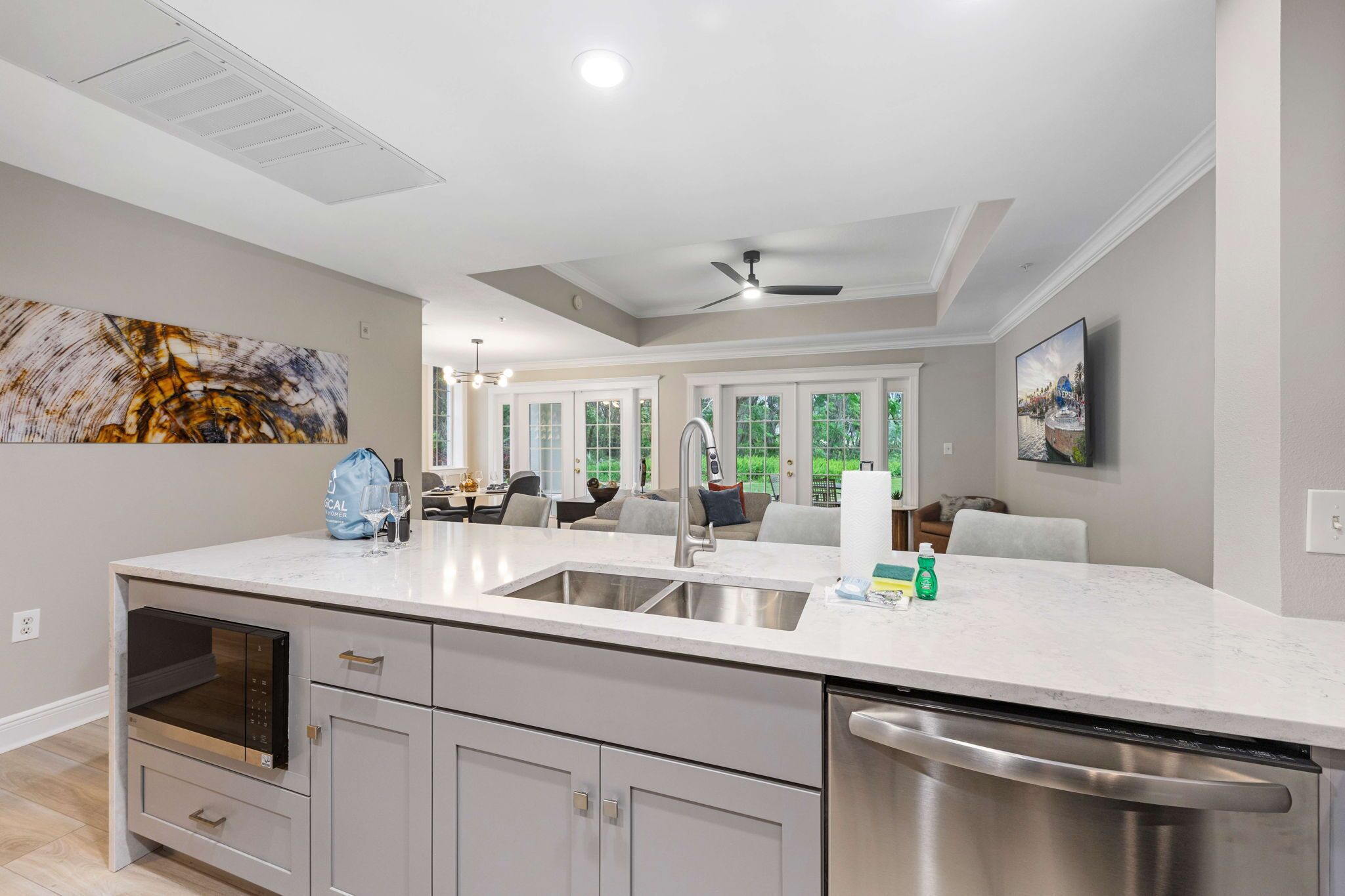 A modern kitchen with a large island, built-in oven, and stainless steel dishwasher.