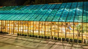 A modern building with a glass facade and a parking lot in front. - Smoky Mountain Resort Luxury Cabin (Gatlinburg)
