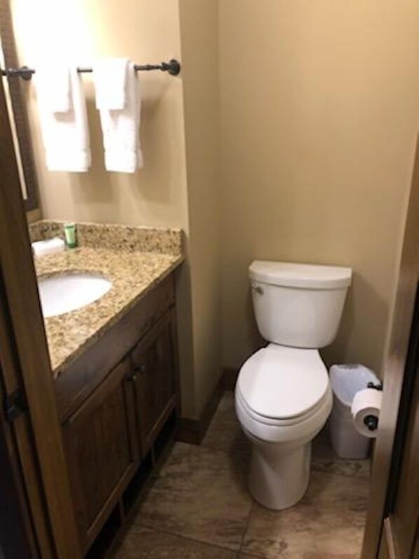 Un baño pequeño con inodoro, lavamanos y un perchero para toallas.