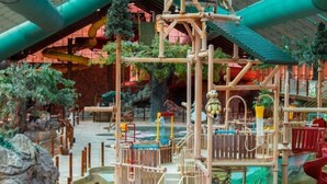 An indoor water park with slides, climbing structures, and a pool area. - Smoky Mountain Resort Luxury Cabin (Gatlinburg)