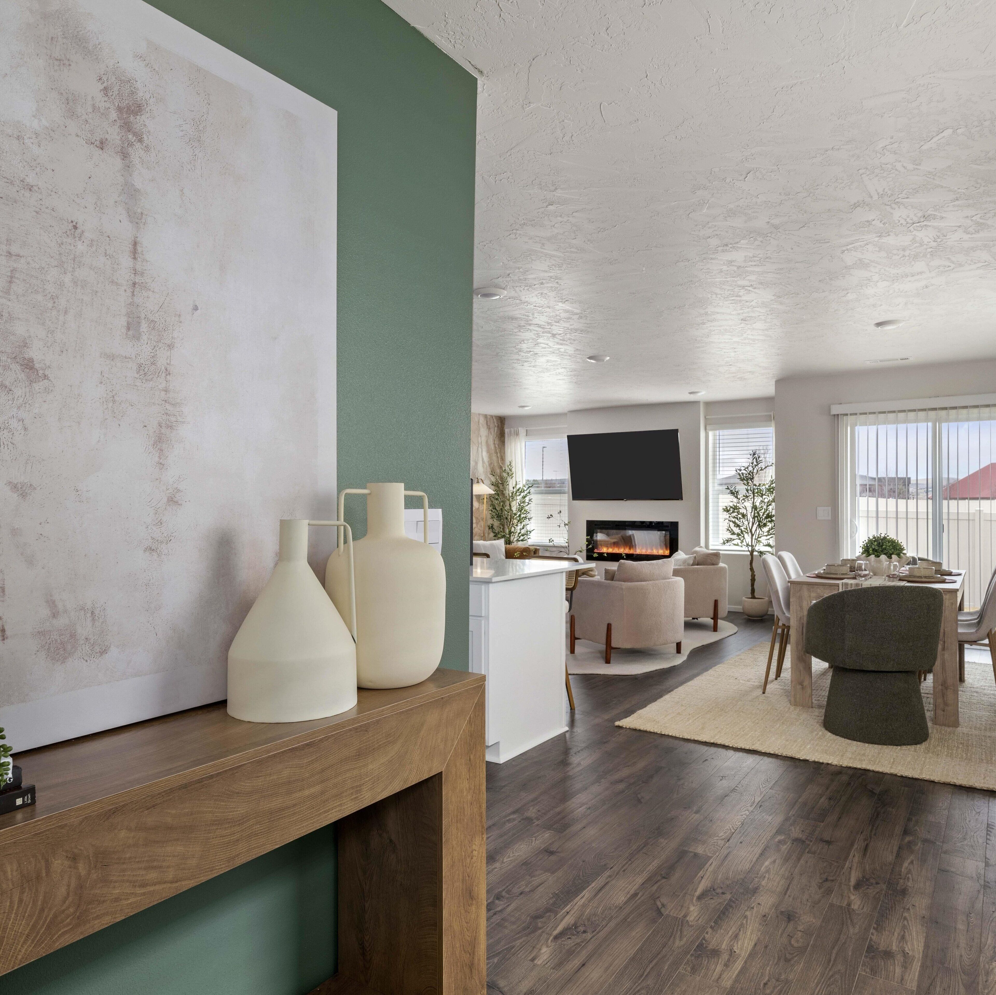 Ein modernes Wohnzimmer mit Kamin, Essbereich und einem großen abstrakten Gemälde an der Wand.