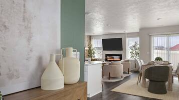 Ein modernes Wohnzimmer mit Kamin, Essbereich und einem großen abstrakten Gemälde an der Wand.