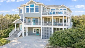 A two-story house with a balcony, a covered porch, and a staircase leading to the entrance.