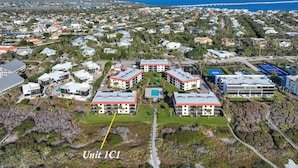 Vista aérea de uma área residencial com vários edifícios, incluindo um prédio de destaque identificado como 