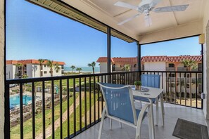 Balcón con vista a la piscina, mobiliario exterior y ventilador de techo.