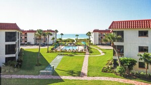 A resort with two-story buildings, a central pool area, and a view of the ocean. - 1BR ocean view condo on Sanibel Island Steps from the beach - Sandalfoot 3B3 (Sanibel Island)
