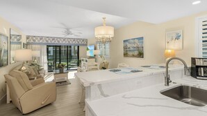 A modern kitchen with a marble countertop, a built-in sink, and a chandelier. - Stunning Sanibel getaway steps to the pool and beach - beach views - Sandalfoot 4A1 (Sanibel Island)
