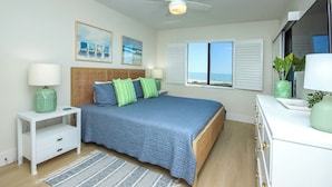A bedroom with a bed, bedside table, and a window with a view.