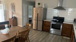 Una cocina moderna con refrigerador de acero inoxidable, horno doble y armarios de madera.