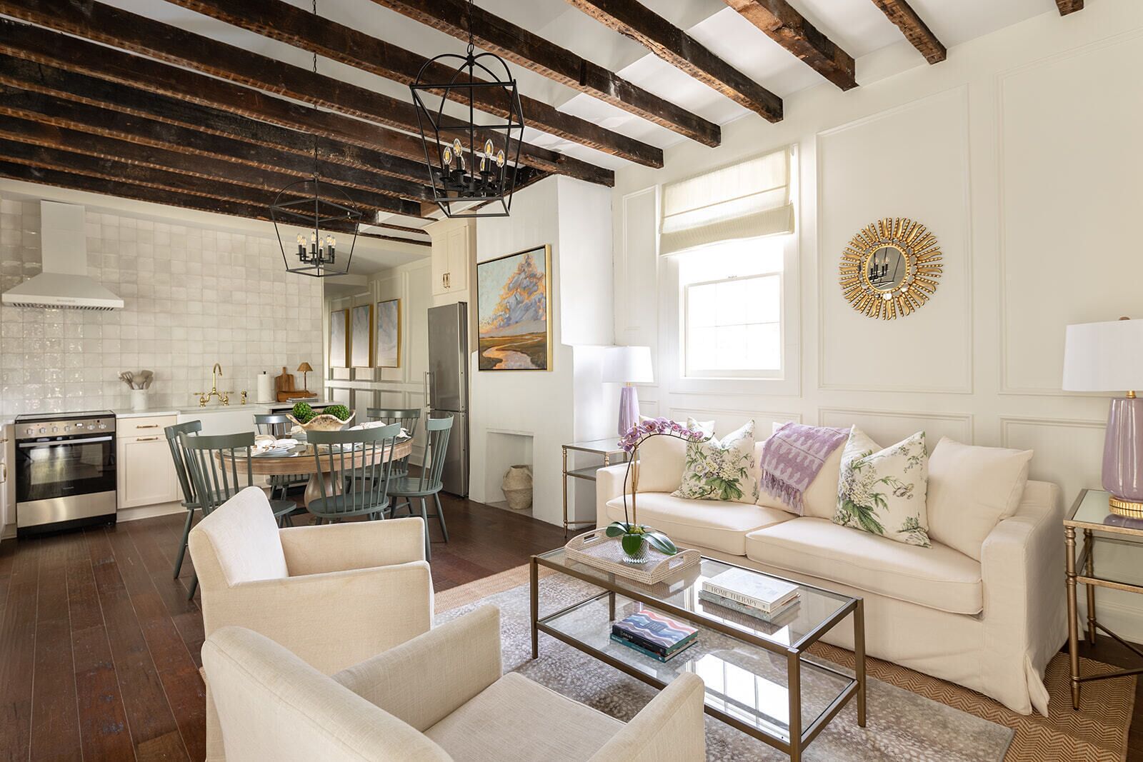A spacious living room with a high ceiling, a dining area, and a kitchen.