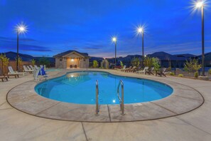 A swimming pool with a circular shape, surrounded by lounge chairs and a small building in the background. - Ladera 379, Private Spa, Smart TVs, Community Pool (Washington)