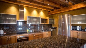 A kitchen with granite countertops, stainless steel appliances, wooden cabinets, and a vaulted ceiling. - Country House 'La Cajola' with Mountain View, Private Pool and Wi-Fi (Lladurs)