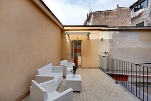 A small outdoor seating area with white wicker furniture and a potted plant. - Guest House 'Love Stabia' with Private Terrace, Wi-Fi and Air Conditioning (Castellammare di Stabia)