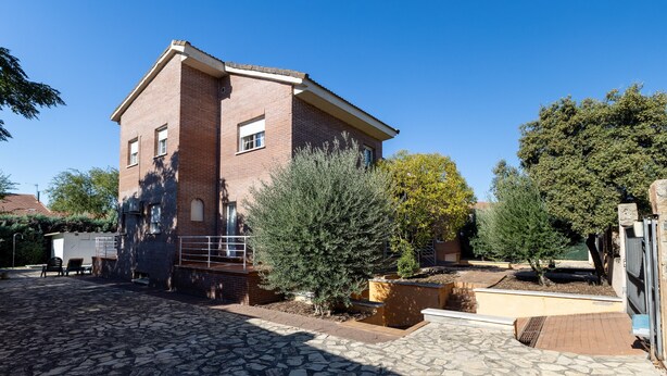 A two-story brick building with a stone-paved courtyard, outdoor seating, and mature trees. - Holiday Home 'Villa Pilara - Brunete' with Private Pool, Wi-Fi and Air Conditioning (Brunete)