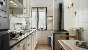 Una cocina con estufa, lavabo y ventana.