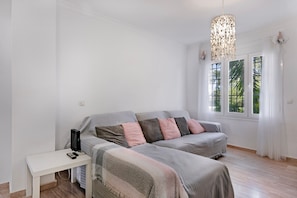A bedroom with a bed, bedside table, and a desk with a computer. - Apartment 'Taymar' with Shared Pool, Wi-Fi, and Air Conditioning (Chiclana de la Frontera)