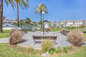 A park with benches, a lamp post, and a playground. - Apartment 'Taymar' with Shared Pool, Wi-Fi, and Air Conditioning (Chiclana de la Frontera)