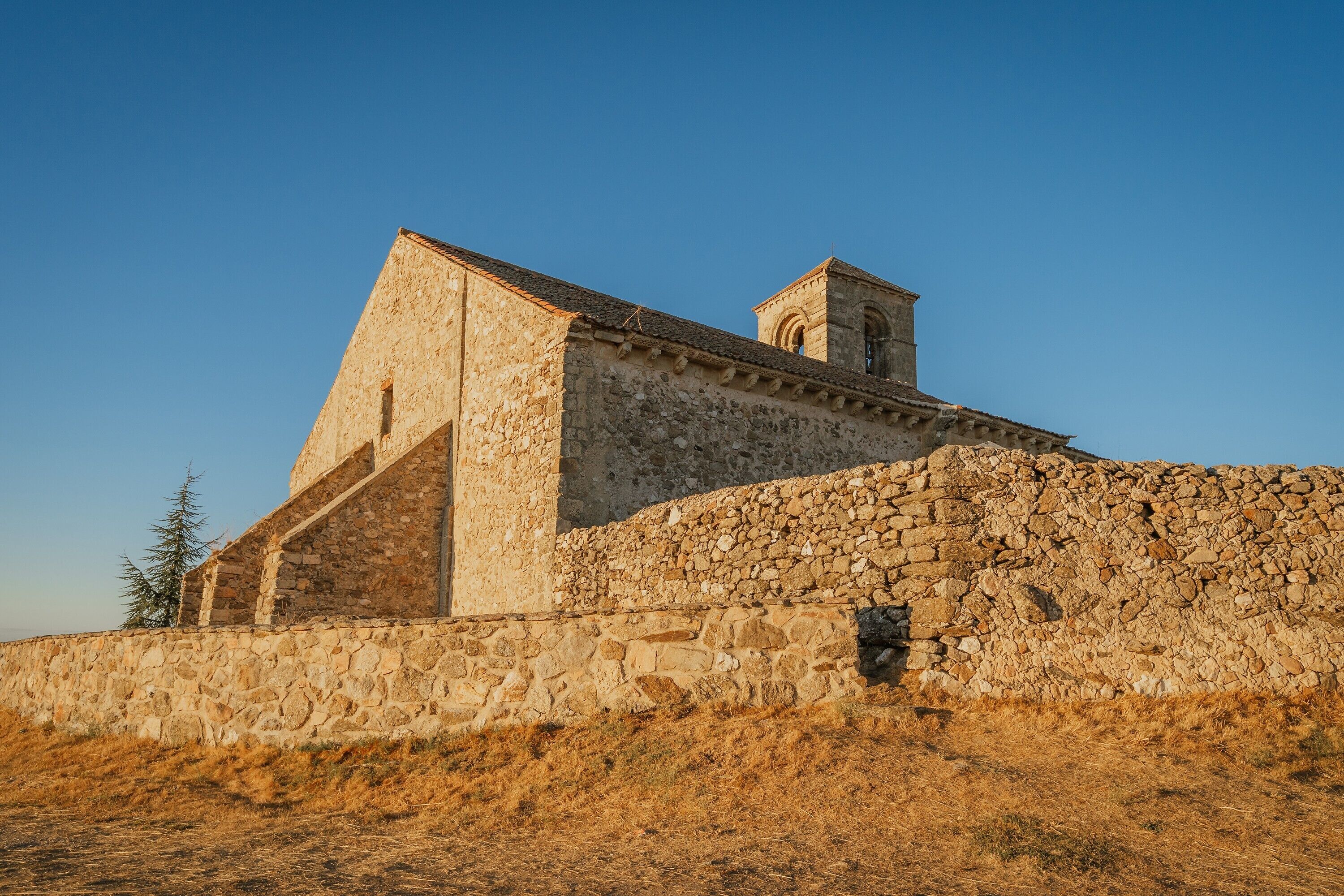 Un bâtiment en pierre doté d’un toit en pente et d’une petite tour.