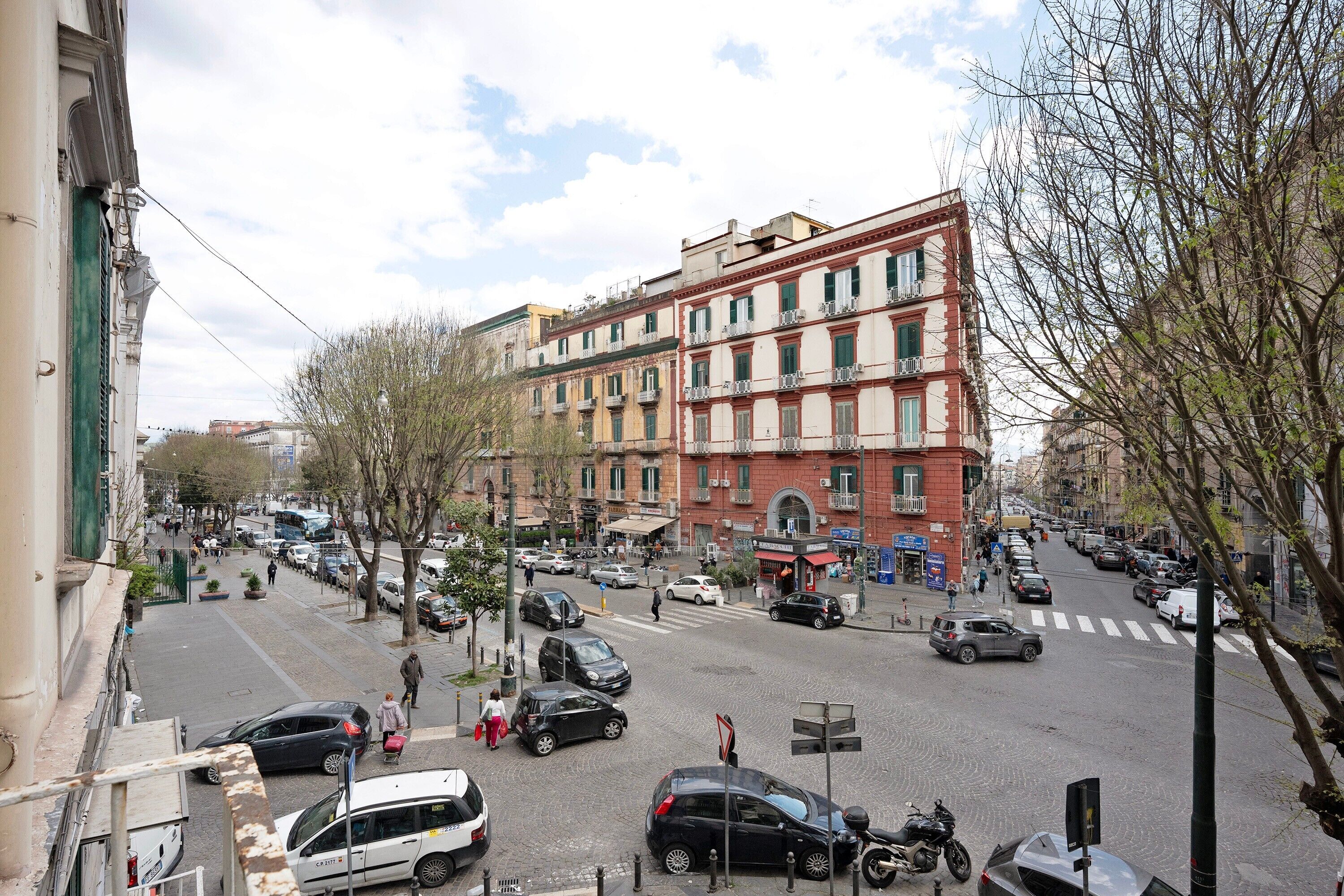 Une vue de rue avec des bâtiments, des voitures et des piétons.