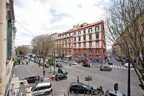A street view with buildings, cars, and pedestrians.