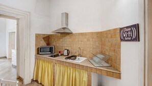 A kitchen with a microwave, kettle, and a 'Free Wi-Fi here' sign.