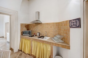 Een keuken met een magnetron, waterkoker en een bordje met daarop 'Gratis Wi-Fi hier'.