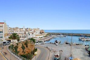 A coastal town with a marina, buildings, and a cliff.