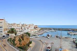A coastal town with a marina, buildings, and a cliff.