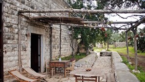 An outdoor patio with stone flooring, wooden furniture, and a pergola structure. - Apartment 'Cerere' with Shared Terrace, Wi-Fi and Air Conditioning (Bisceglie)