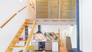 A compact kitchen with a checkered backsplash, a built-in stove, and a small refrigerator.