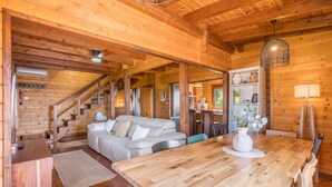 A wooden cabin interior with a dining table, sofa, and staircase. - Holiday Home 'La Haima' with Sea Views, Wi-Fi and Air Conditioning (Motril)